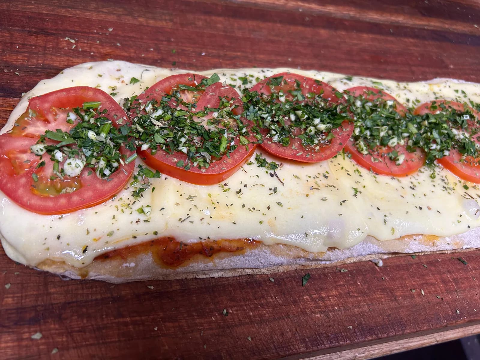 PIZZA CON SALSA DE TOMATE, MUZZARELLA, TOMATE, AJO Y PEREJIL